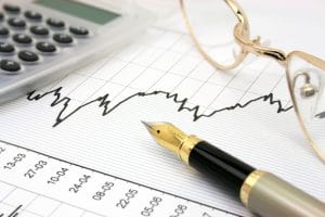 Stock chart with calculator, fountain pen and eyeglasses